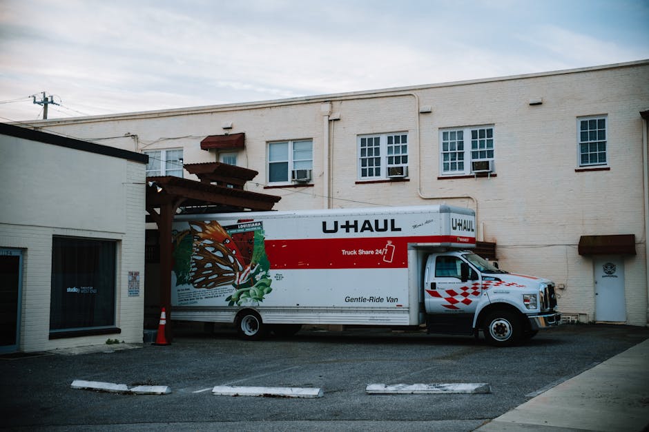 A moving truck parked securely outside a beautiful residential home